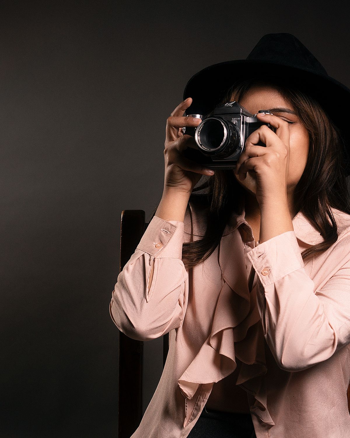 Mara Halvorsen holding a film camera to her eye.