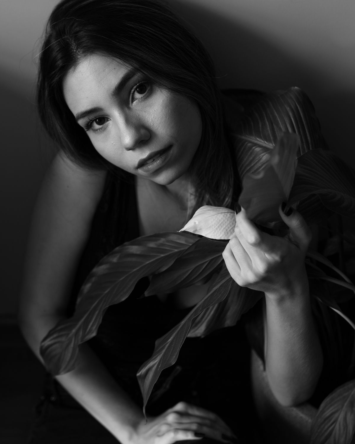 Black and white portrait of a woman turning away from a hard sidelight.