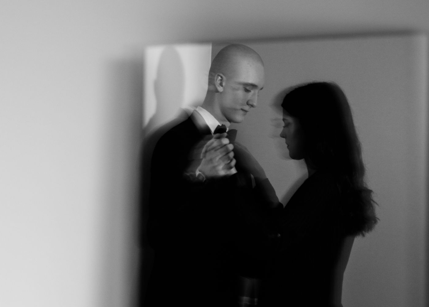 A couple embracing, seen softly through frosted glass.