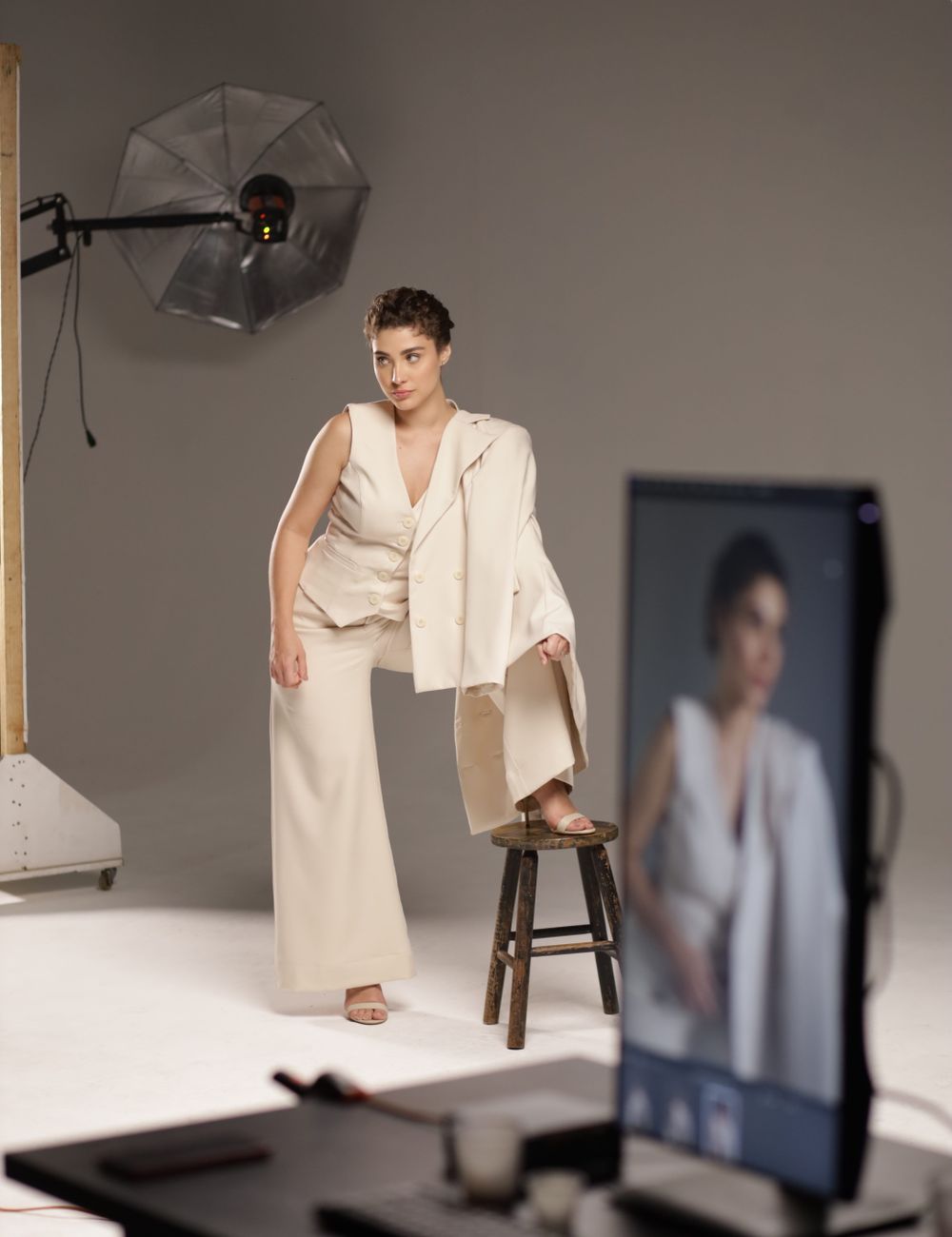 Model on a set with lighting stands and a paper backdrop.