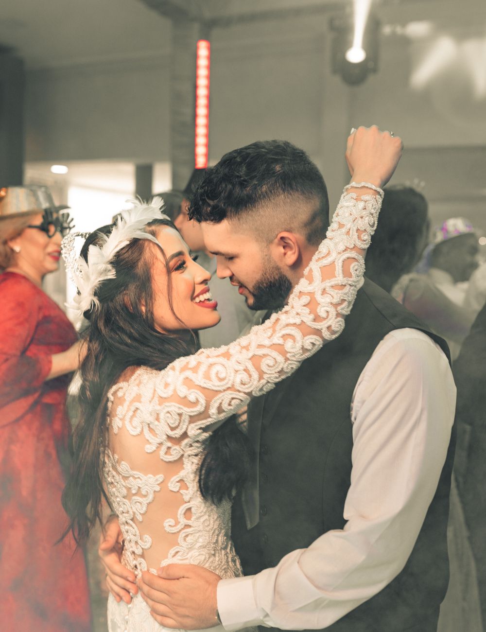 Couple dancing surrounded by guests at a wedding.